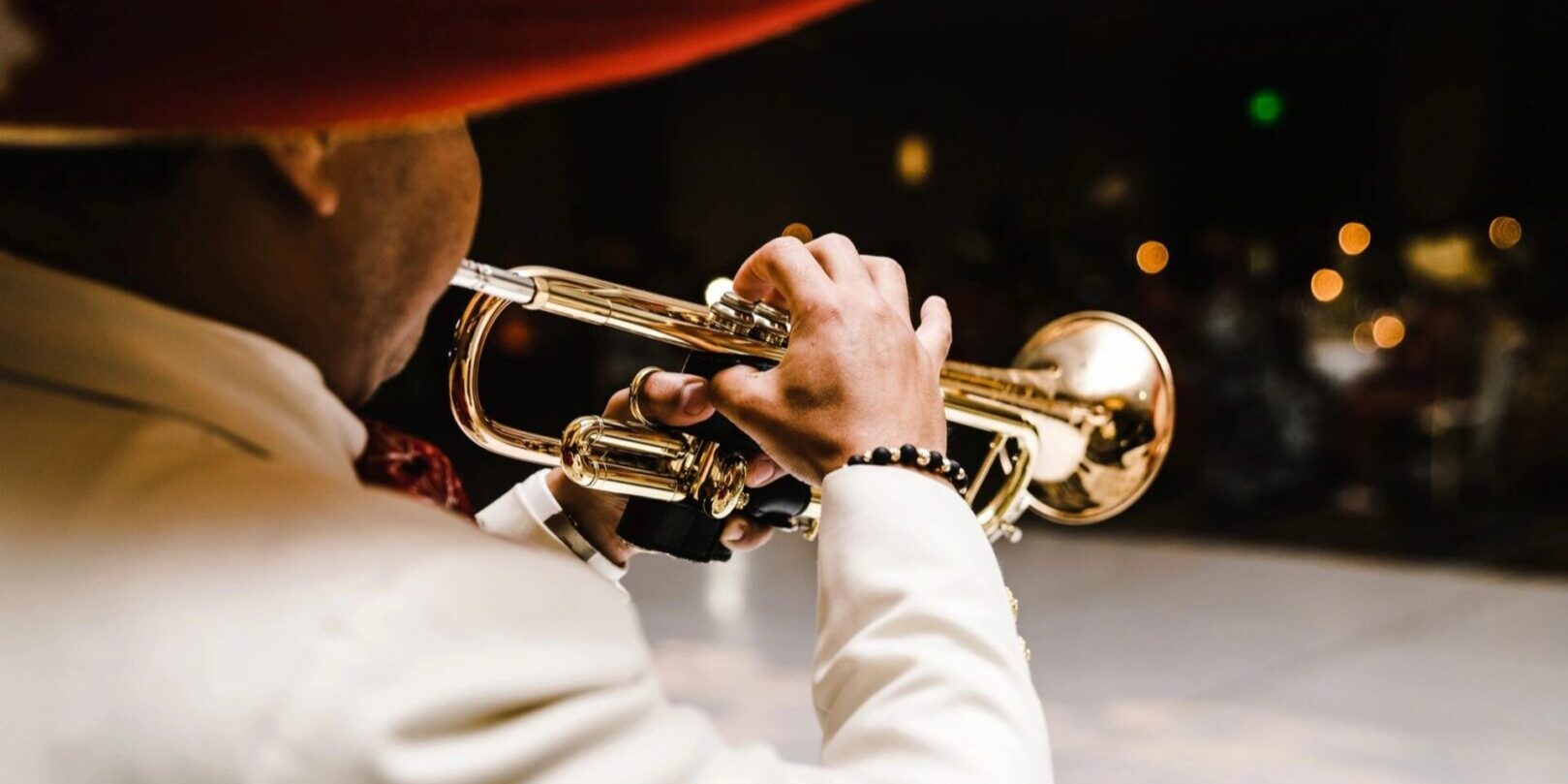 A man playing the trumpet in front of some lights